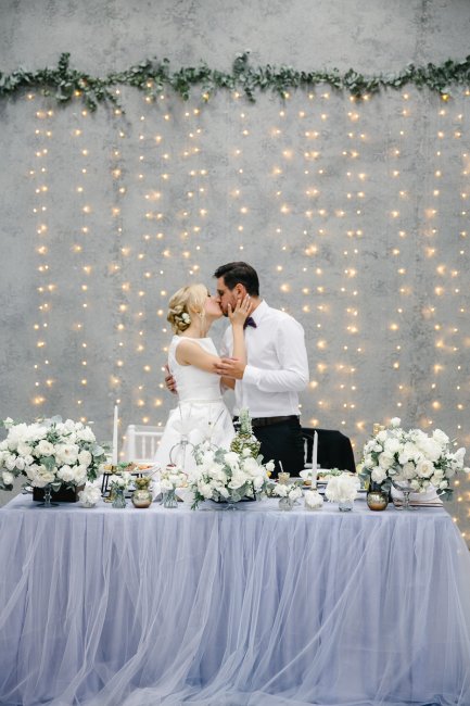 Жених и невеста за столом с цветами
