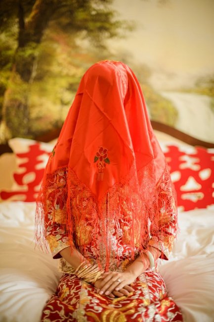 Лицо невесты по древнему обычаю скрывает красная вуаль