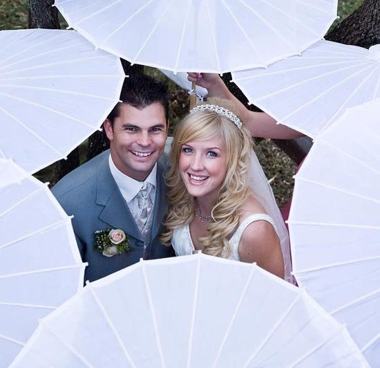 Жених и невеста, окруженные зонтами