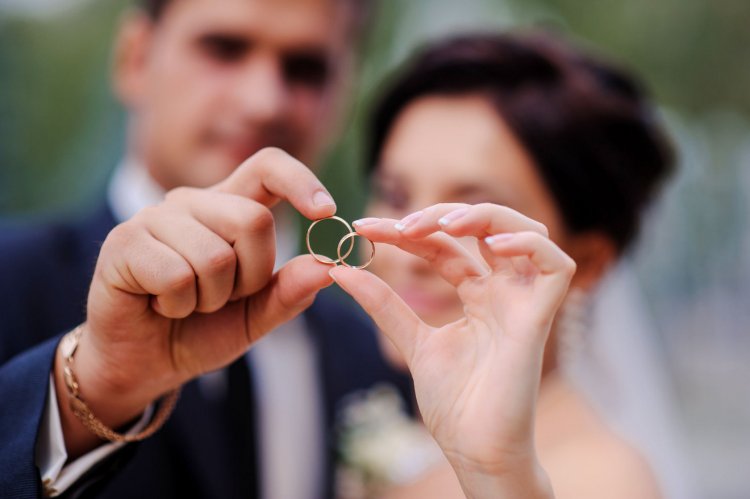 Жених и невеста держат обручальные кольца