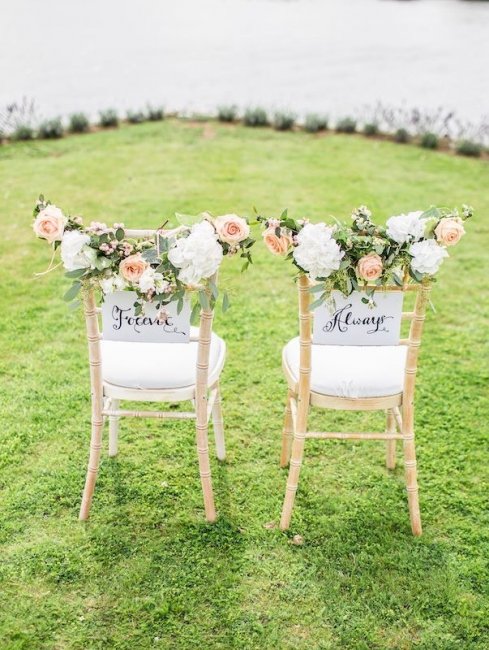 Цветочные гирлянды в декоре стульев на весенней свадьбы