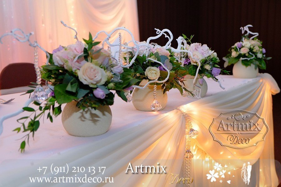 Цветы в вазах на свадебном столе жениха и невесты.