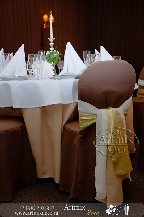 Стулья гостей на свадьбе, оформлены широкой лентой