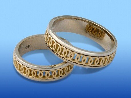 Кольцо из белого и лимонного золота украшено узором, олицетворяющим соединенные свадебные кольца – п