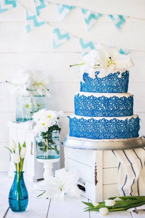Свадебный торт с кружевом и живыми цветами.